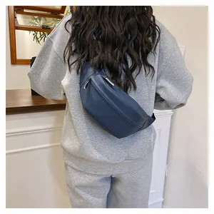 Detail view of the navy blue nylon sling bag worn as a stylish backpack on a model