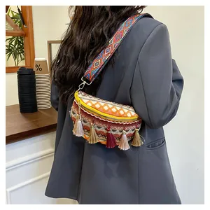 Detail of bohemian woven belt bag with colorful tassels and geometric patterns on a model