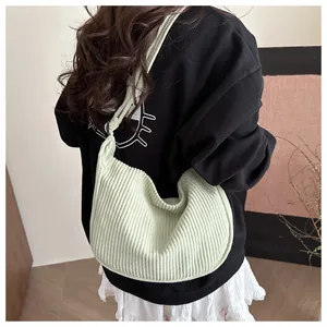 Detailed texture of light green corduroy hobo bag with unique knotted shoulder strap