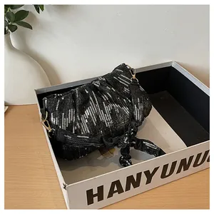 Detalle del bolso plisado negro con lentejuelas plateadas y gancho de metal dorado chic