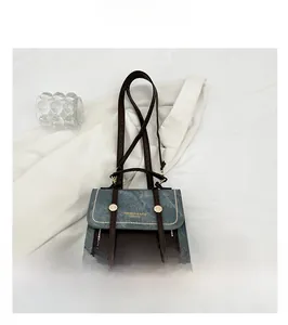 Détails du sac en denim bleu et cuir marron avec broderie de logo élégante