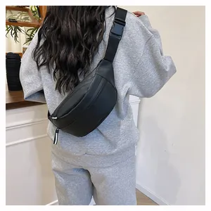Rear view of black waterproof crescent waist bag worn as a crossbody chest pack on a model