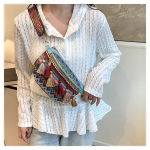 Close-up of bohemian woven crossbody bag with colorful tassels and patterned strap