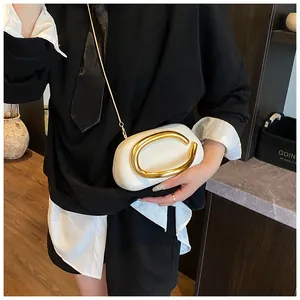 Detail of white leather mini bag featuring iconic gold C-logo metal buckle and chain strap