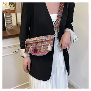 Detail of woven ethnic fanny pack featuring colorful tassels and a geometric pattern strap