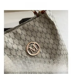 Gros plan du logo M doré et de l'imprimé lettres sur le sac en cuir synthétique