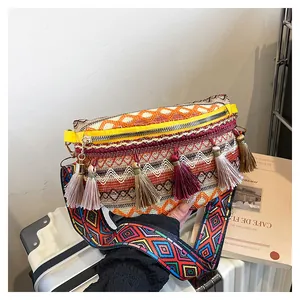 Detailed shot of bohemian woven waist bag with colorful tassels and geometric ethnic strap