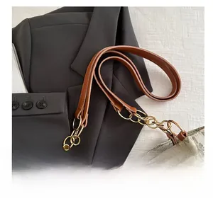 Détail de la poignée en cuir avec chaîne dorée sur le sac cabas à monogramme