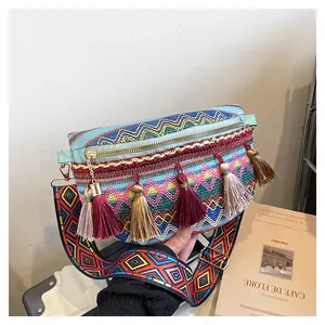 Close-up of bohemian embroidered sling bag with colorful fringe and woven strap details