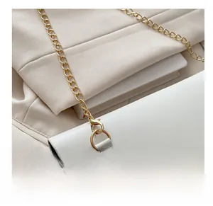 Close-up of premium white leather bag detailing with luxury gold hardware chain strap