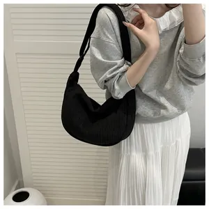 Detail of black corduroy shoulder bag with soft texture and minimalist metal zipper