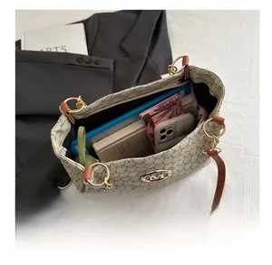 Vue de dessus d'un grand sac cabas gris avec livres, tablette et téléphone