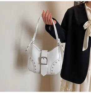 Detail der weißen PU-Ledertasche mit großer Silberschnalle und verknotetem Griffdesign
