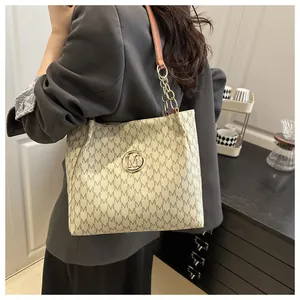 Détail du sac cabas crème avec motif monogramme M et logo métallique doré chic