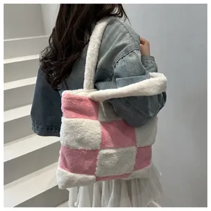 Dettaglio della borsa tote in peluche a scacchi rosa e bianchi indossata a spalla su set