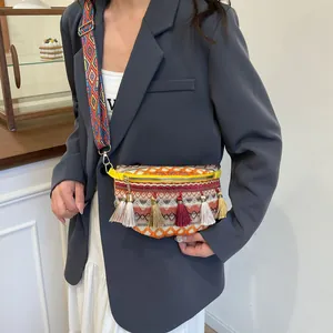 Bohemian woven crossbody bag with colorful tassels and geometric patterns on a wide strap