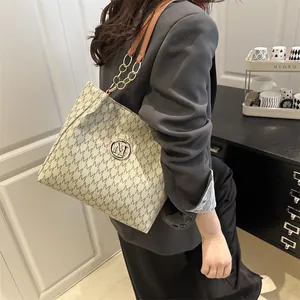 Chic beige tote bag with M-letter print and chain shoulder strap shown on a model