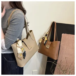 Detailaufnahme der Leder-Tote-Tasche mit goldener Schnalle und Vintage-Seidenschal