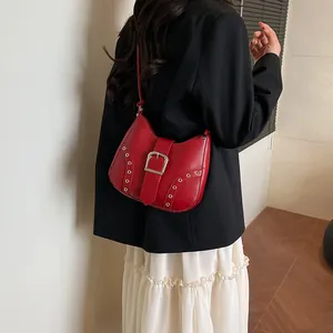 Schicke rote Leder-Unterachseltasche mit Silberschnalle und Ösen auf schwarzem Blazer