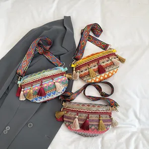 Ethnic bohemian woven fanny pack with colorful tassels and wide patterned shoulder strap