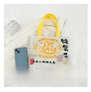 Canvas bucket bag with yellow straps and Chinese folk art print showing size reference