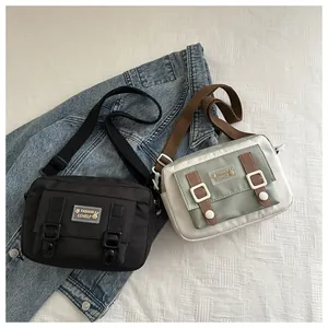 Close-up van canvas crossbodytassen in zwart en groen met decoratieve gespen en riemen