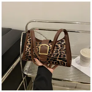Detailansicht des Leopardenmusters mit braunem Lederbesatz und goldener Schnalle der Tasche