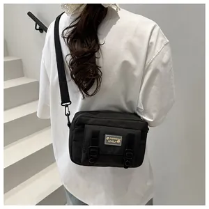 Detail van zwarte crossbody tas met decoratieve gespen en riem gedragen door model