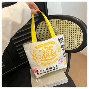 Close-up of canvas bucket bag with Chinese calligraphy and yellow top handles