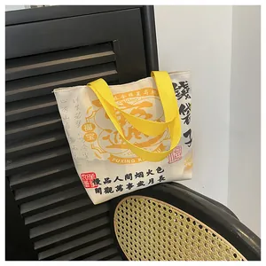 Detail of canvas bucket bag with yellow straps and Chinese New Year calligraphy