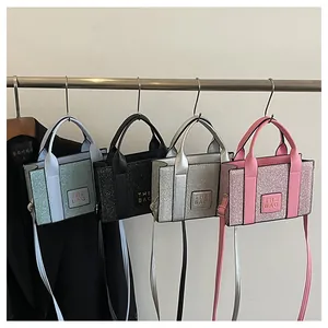 Quatre mini sacs cabas pailletés en vert, noir, argent et rose suspendus avec un blazer