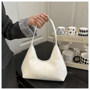 Macro shot of white snakeskin texture on a curved hobo bag with silver zipper detail