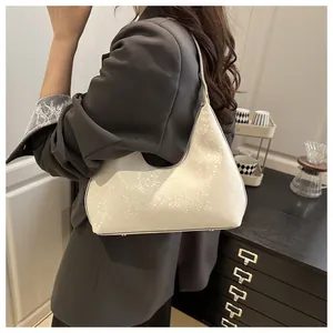 Minimalist beige snakeskin pattern hobo bag shown worn on shoulder by a model