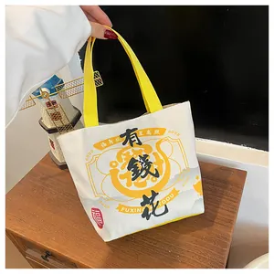 Detail of canvas bucket bag with yellow handles and traditional Chinese lucky character print