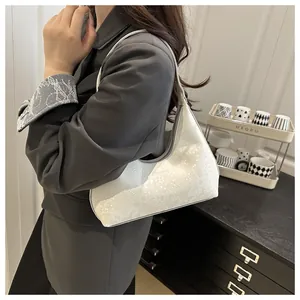 Detail of white snakeskin texture hobo bag worn over shoulder with sleek minimal design