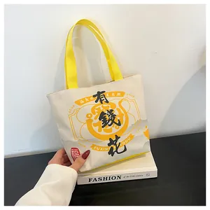 Close-up of canvas bucket bag with festive Chinese characters and yellow strap handles