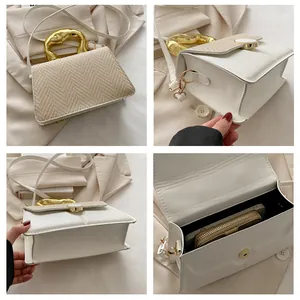 Detail showing white leather and fabric patchwork bag with a unique gold metal handle