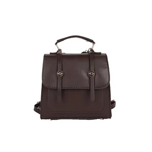 Sac à dos à main vintage en cuir marron foncé avec boucles dorées sur fond blanc