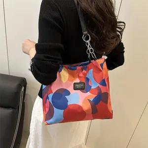 Vibrant geometric print tote bag with contrast colors and metal chain shoulder straps