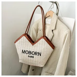 Detalle del bolso tote de paja con ribete de cuero y bordado de Moborn Paris