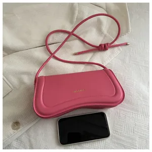Detail of rose pink matte leather shoulder bag with gold XM & BAGS text and phone size reference