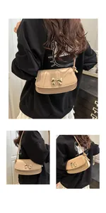 Détail du sac beige avec boucle en nœud doré et bandoulière à nœud décoratif latéral