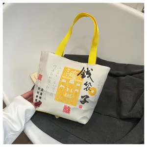 Detail of canvas bucket bag with yellow handles and traditional Chinese lucky art