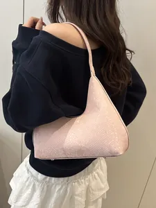 Pink snake pattern hobo bag worn by model, showing the half-moon shape and minimalist design