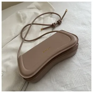 Close-up of khaki shoulder bag with gold XM & BAGS text and slim drawstring strap