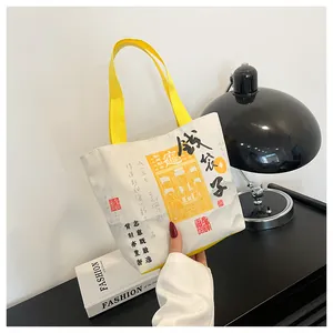 Detail view of durable canvas bucket bag with yellow straps and Chinese folk art prints