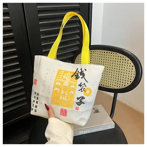 Detail of canvas bucket bag with Chinese calligraphy and yellow handles in lifestyle setting