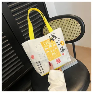 Detail of canvas bucket bag with yellow handles and retro Chinese calligraphy artwork
