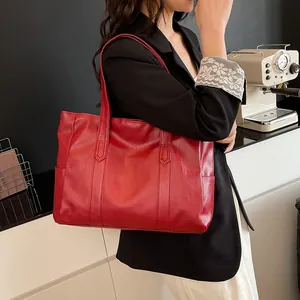 Λεπτομέρεια κόκκινης τσάντας tote με μαλακή υφή δέρματος και κάθετες ραφές στο σώμα