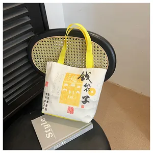Detail of canvas bucket bag with Chinese calligraphy and yellow handles on vintage chair